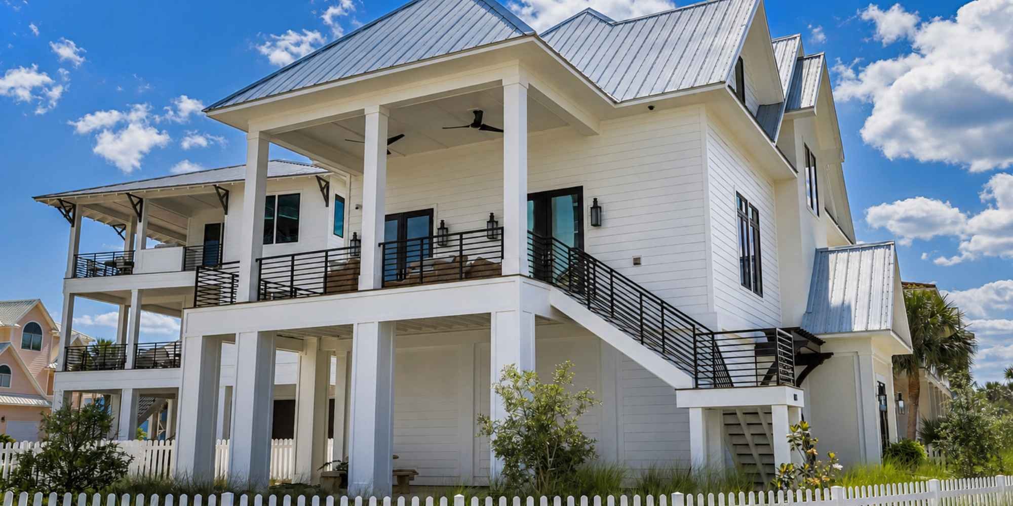 A custom home built on a piling foundation with an elevated covered porch and multiple balconies by Urban Infill in Pensacola, FL.