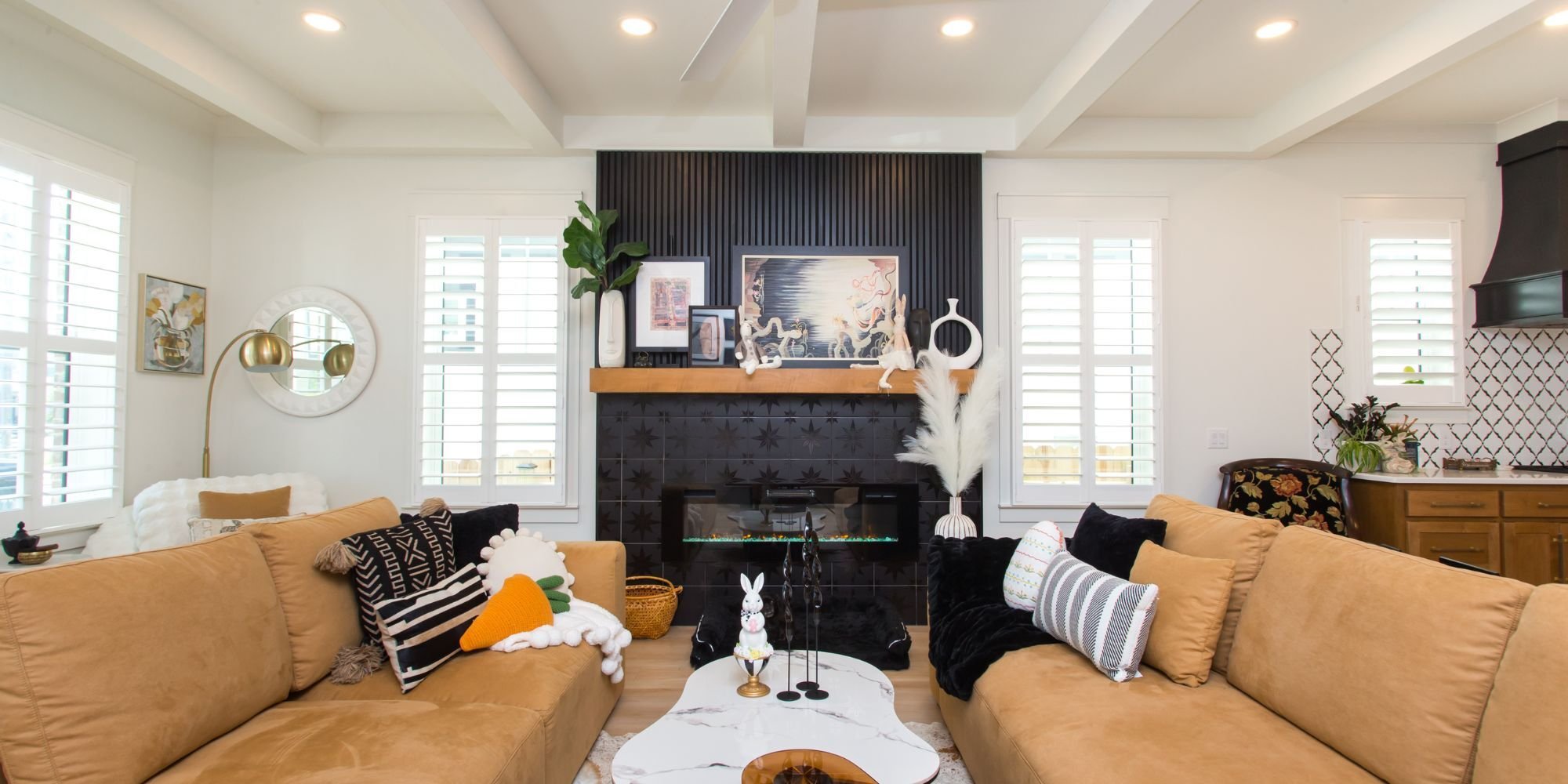 A remodeled living room as part of a whole home remodel in Pensacola, FL with a fireplace, hardwood floors, and plenty of natural light by Urban Infill