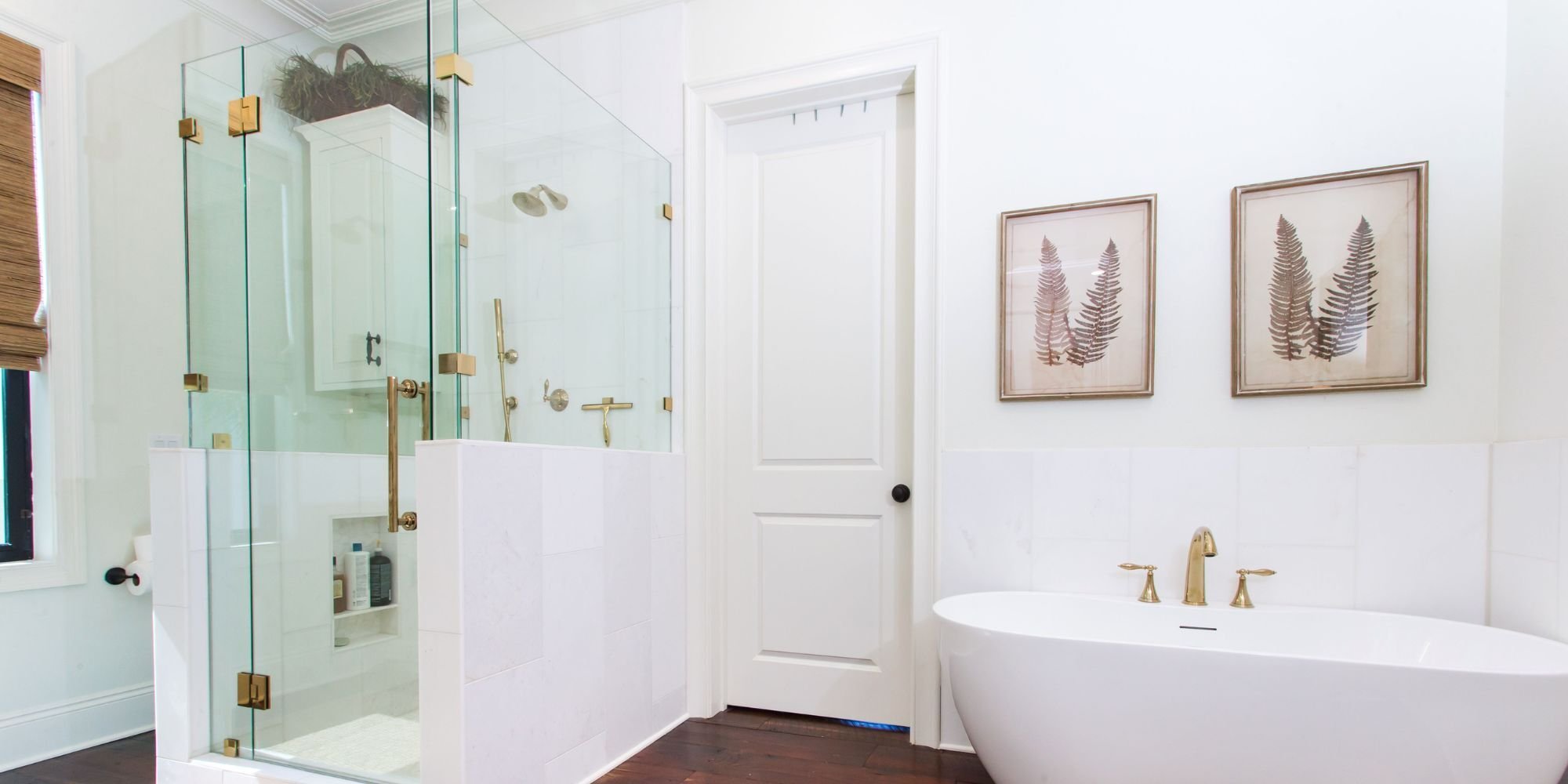 Bright bathroom remodel in Pensacola, FL with a glass shower and standalone soaking tub by Urban Infill