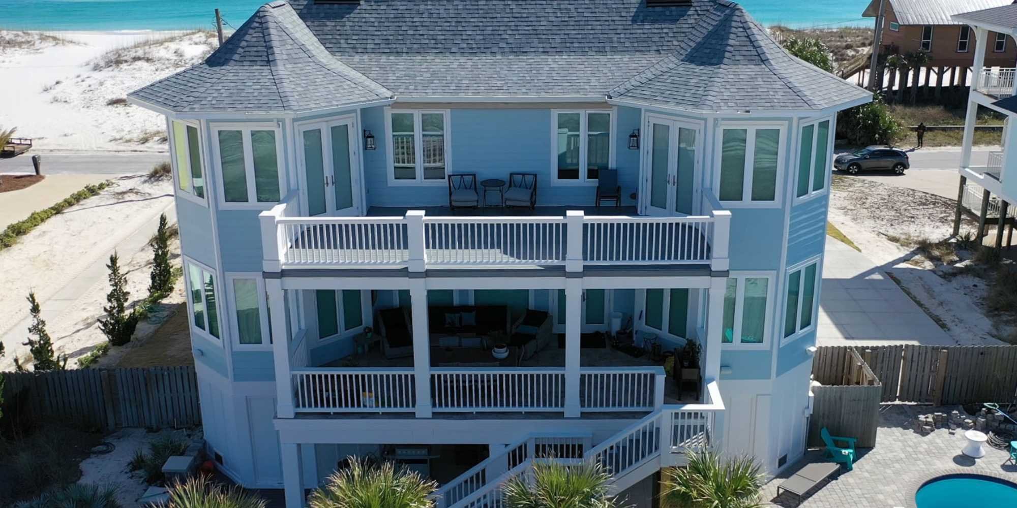 A custom beach home in Pensacola, FL with balconies on the second and third levels by Urban Infill Co