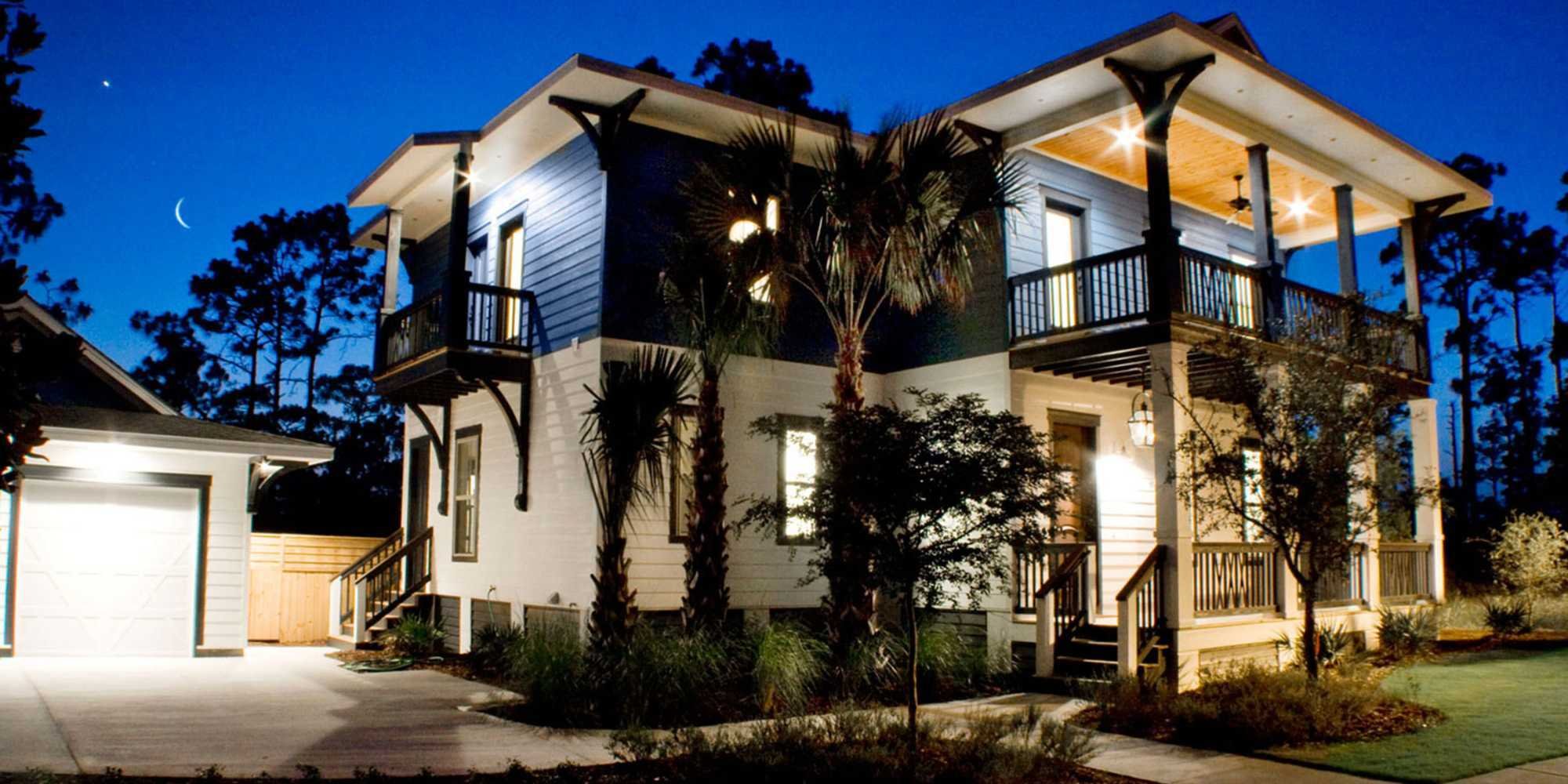 A custom home with a porch and multiple balconies in Pensacola, FL by Urban Infill Co