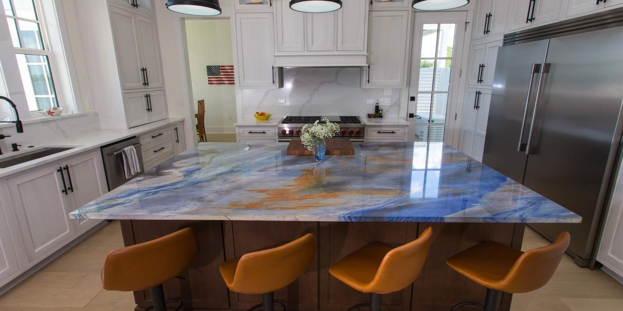 Custom kitchen island with bold blue and orange stone in Innerarity Island, FL by Urban Infill