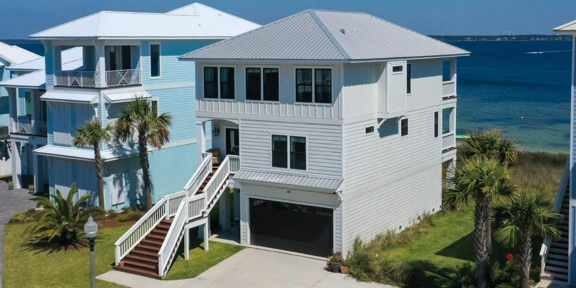 Modern beach house with raised entry and ocean backdrop, built by Urban Infill in Pensacola Beach, FL