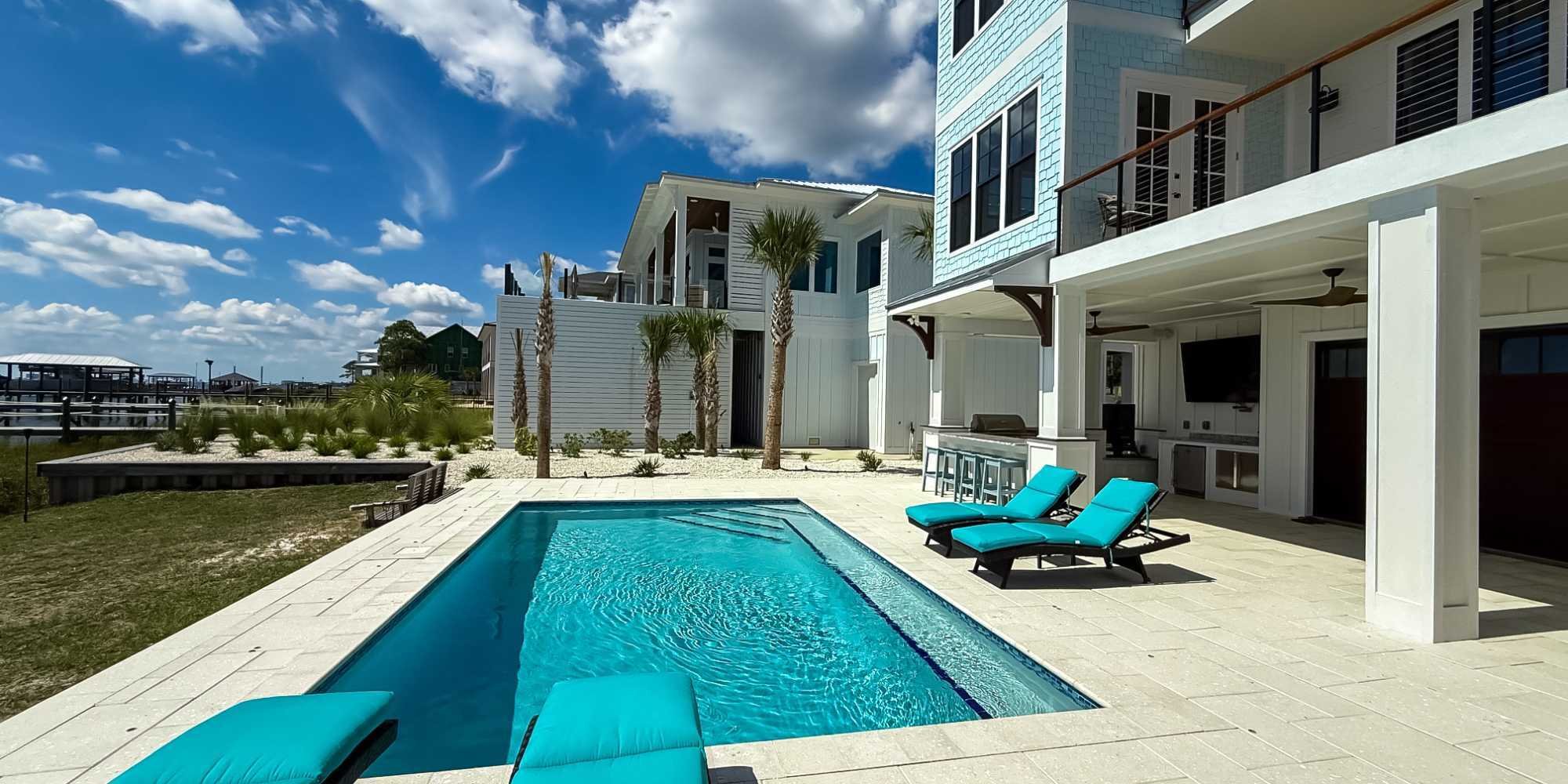 Outdoor living space with an outdoor kitchen, pool, and patio in Pensacola, FL