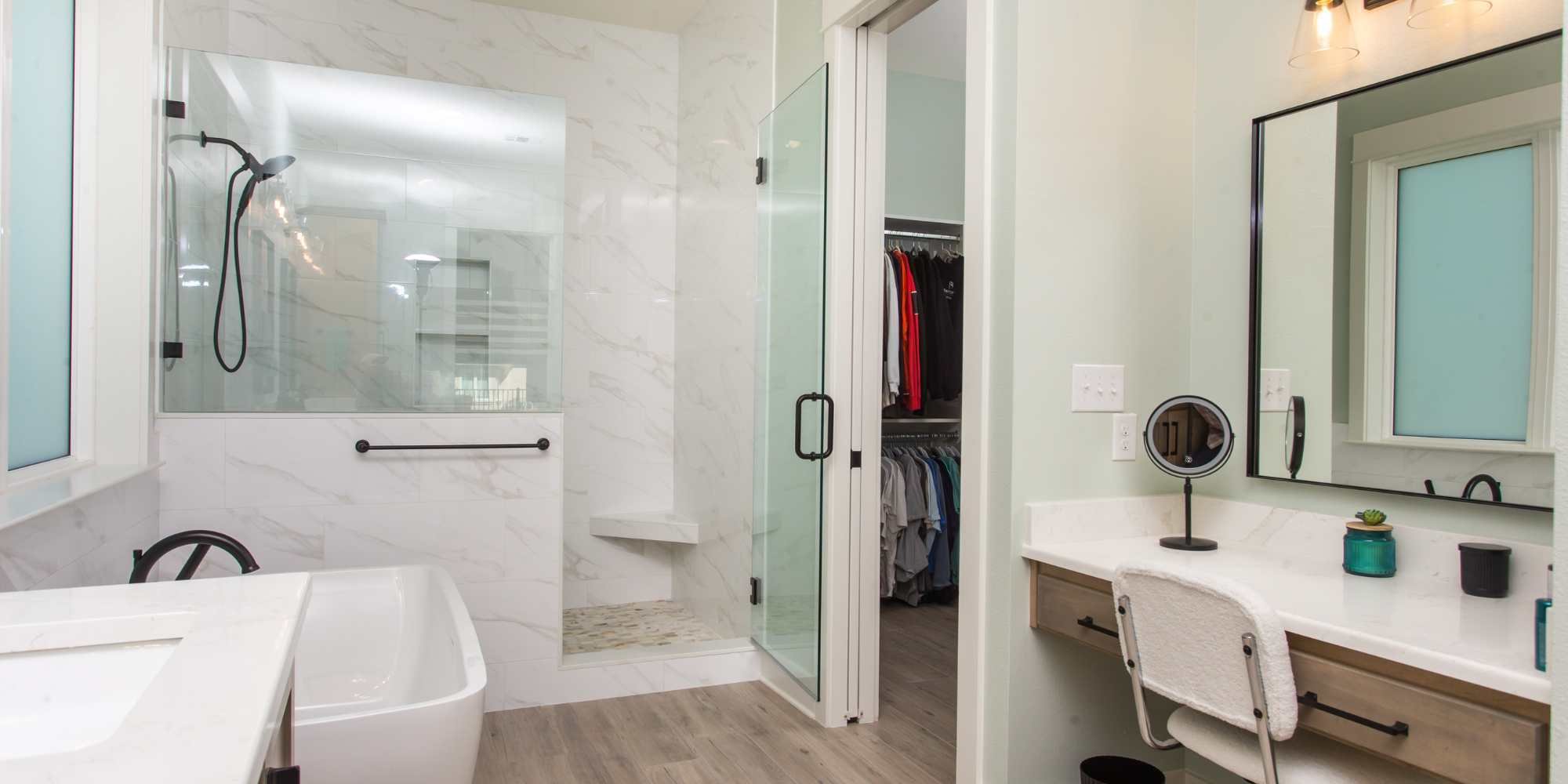 A lowered skincare station and walk-in closet in a custom bathroom by Urban Infill in Pensacola, FL