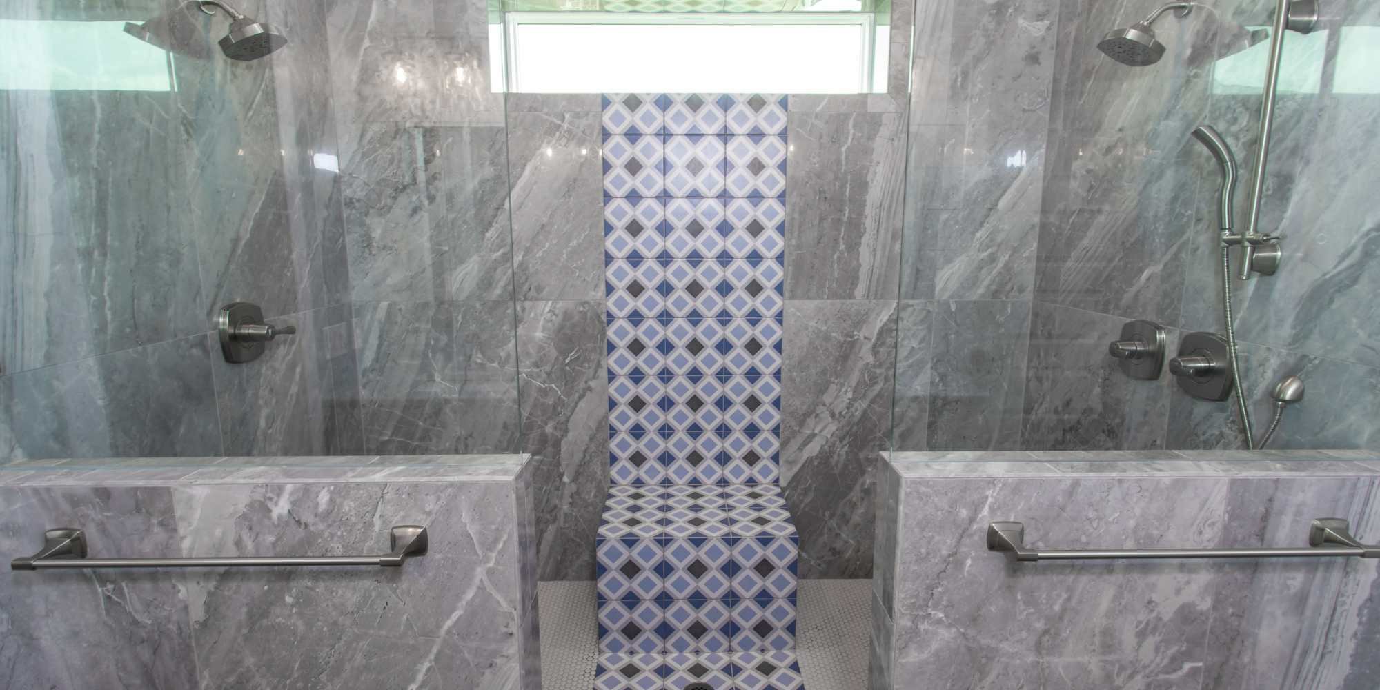 Grande-lagoon shower with dual shower heads, railing, and seating in a custom home by Urban Infill