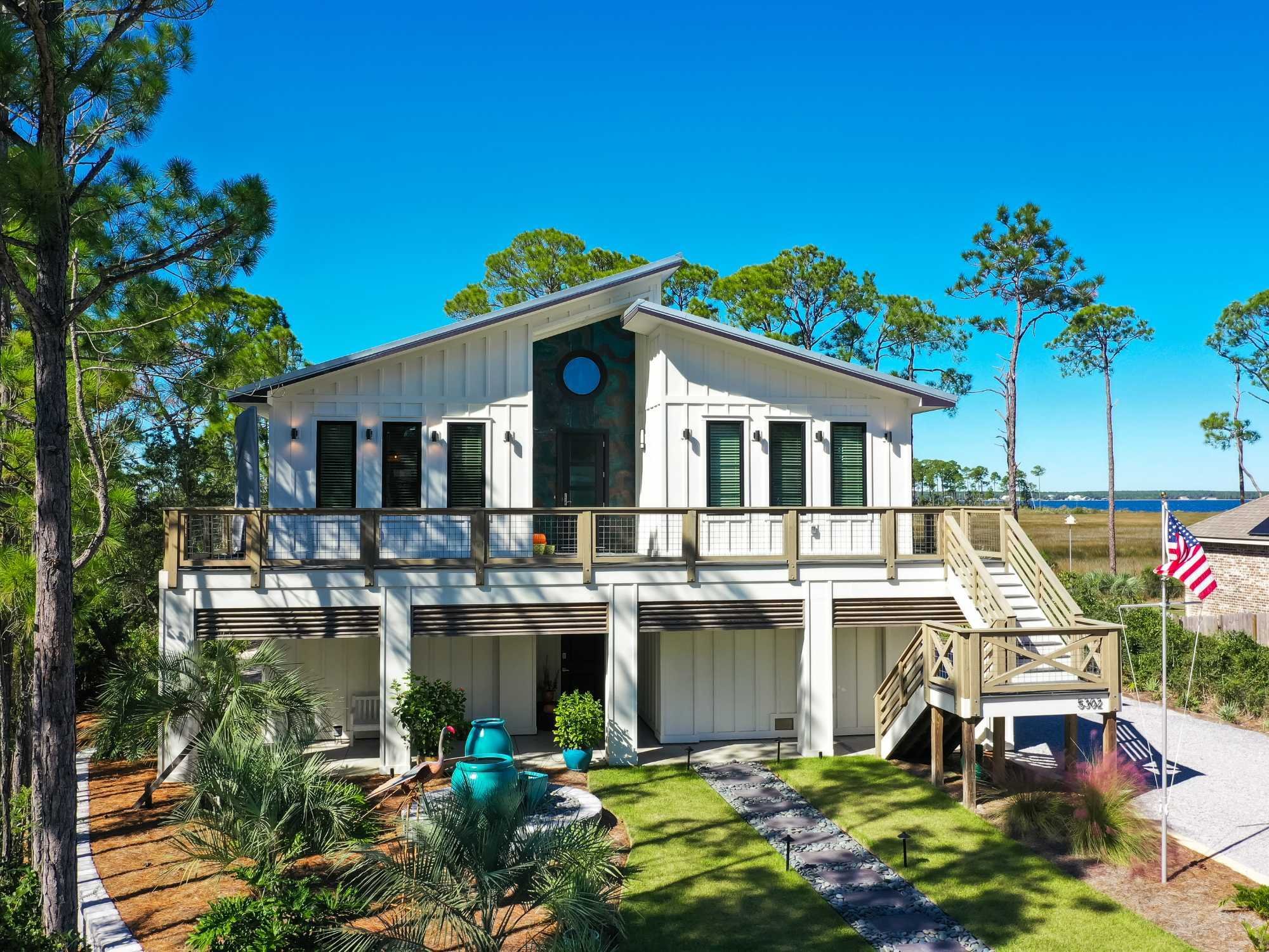 Image of custom home with elevated design, wraparound deck, and coastal views in Pensacola, FL by Urban Infill Image of custom home with elevated design, wraparound deck, and coastal views in Pensacola, FL by Urban Infill