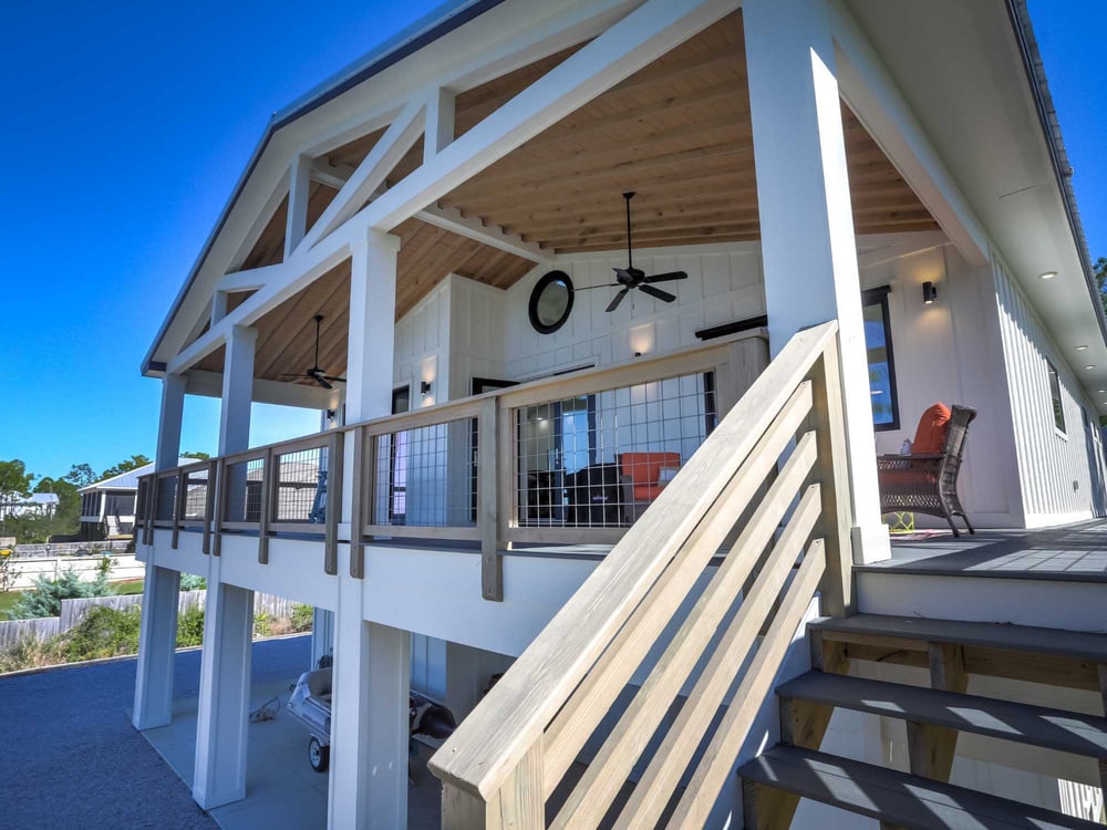 Image of custom home with raised foundation, wraparound porch, and outdoor living space in Pensacola, FL by Urban Infill