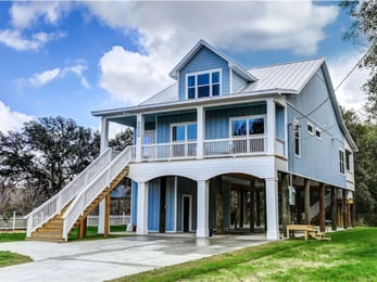 Image of piling home with elevated design, wraparound porch, and coastal architecture in Pensacola, FL by Urban Infill