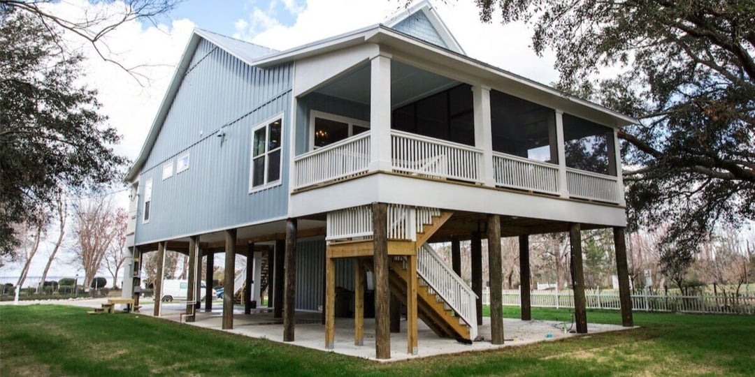 Elevated blue coastal home in Pensacola with screened porch by Urban Infill, custom builder and remodeler