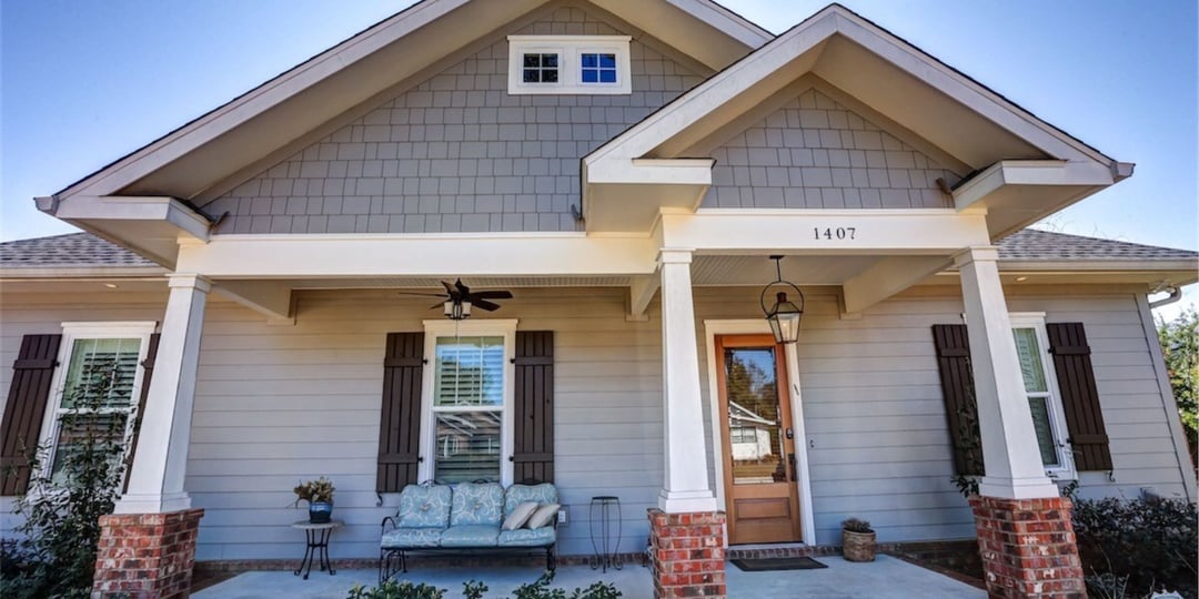 Pensacola custom-built home with covered front porch and wood shutters by Urban Infill