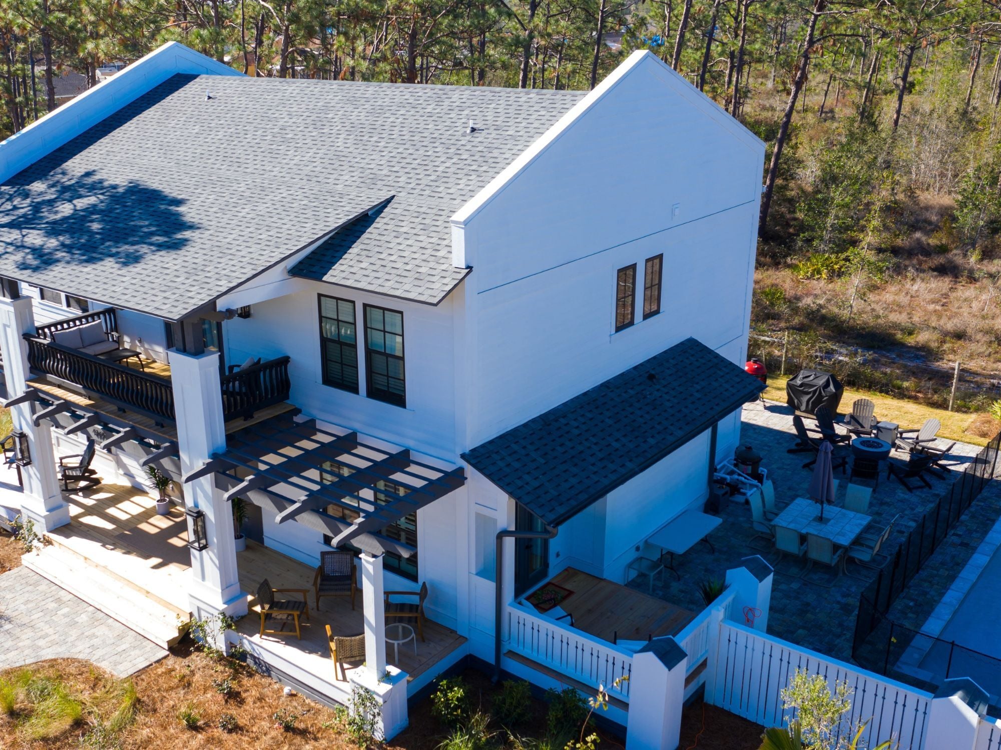 Aerial view of a Leeward custom home with Florida vernacular architecture and a pool by Urban Infill in Pensacola, FL