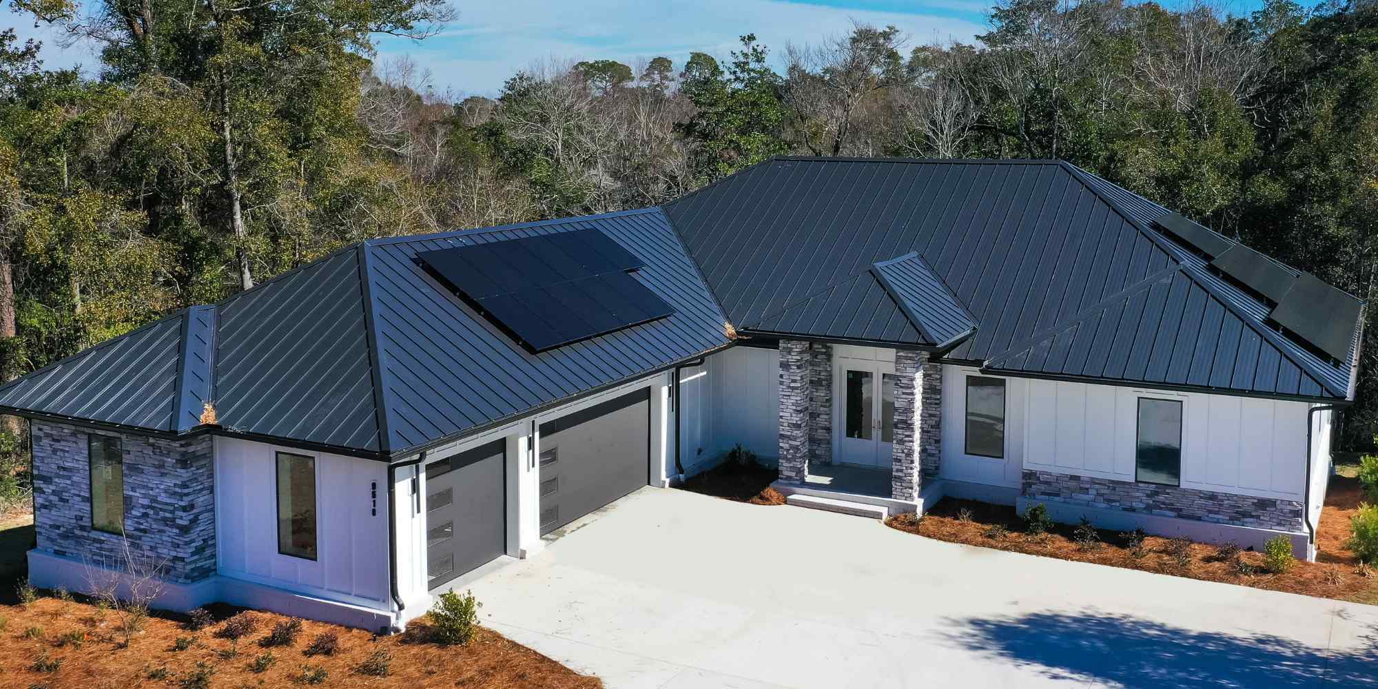 Image of custom home with modern exterior, metal roof, and solar panels in Pensacola, FL by Urban Infill